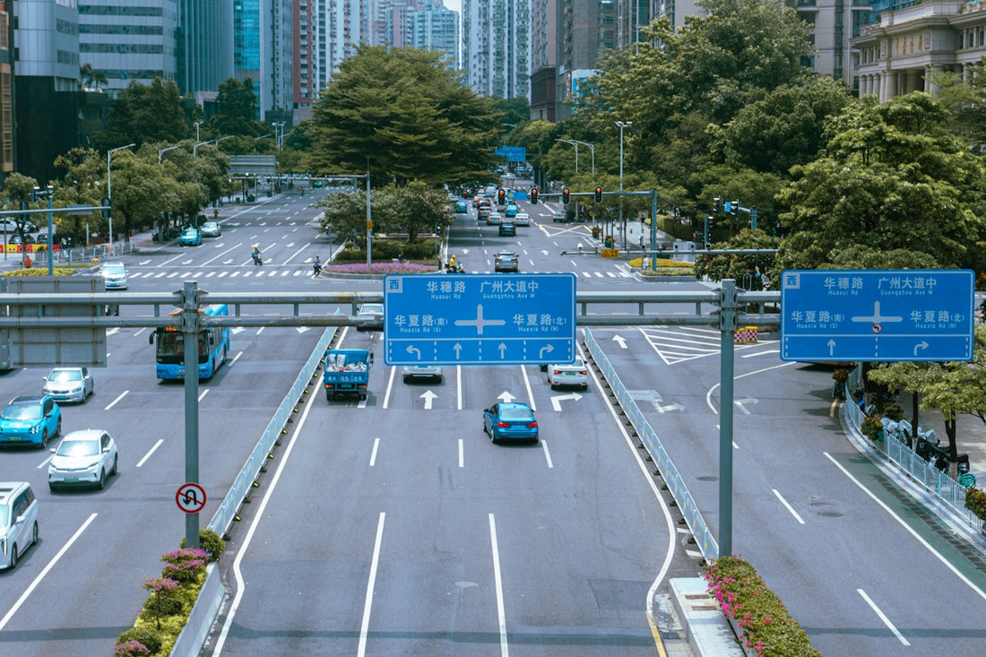 a city street filled with lots of traffic next to tall buildings